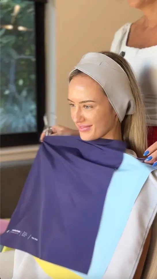 A client being draped in navy and sky-blue fabrics during a color consultation