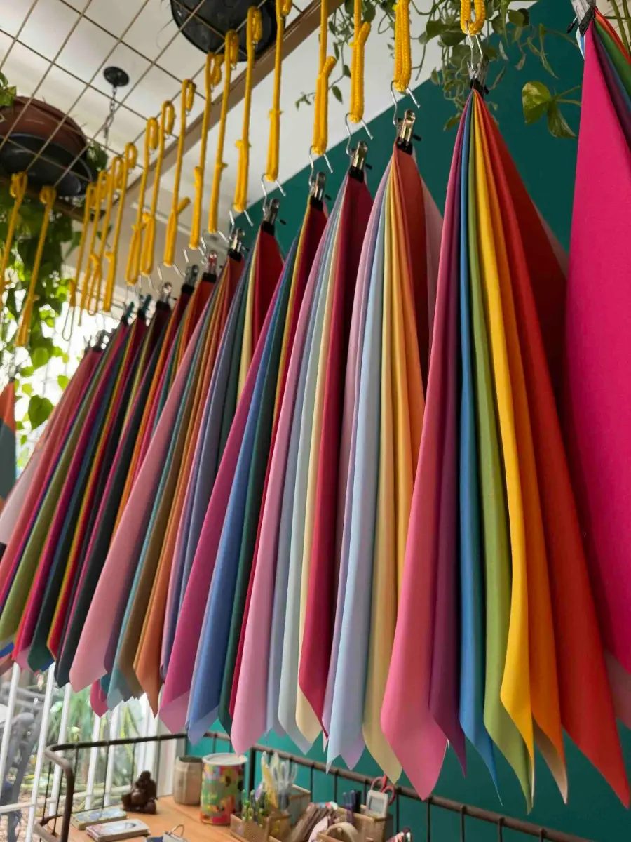 Dozens of Drops de Cor solid color drapes hanging in a studio