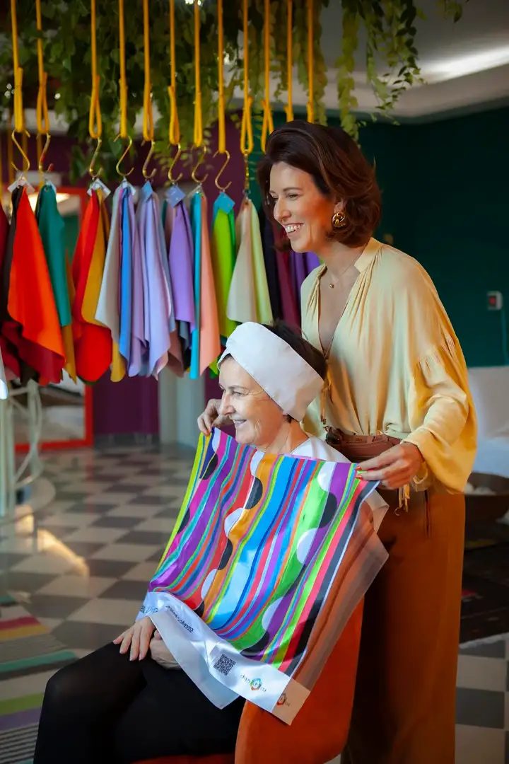 A color analyst drapes a client in saturated fabrics during a Drops de Cor session