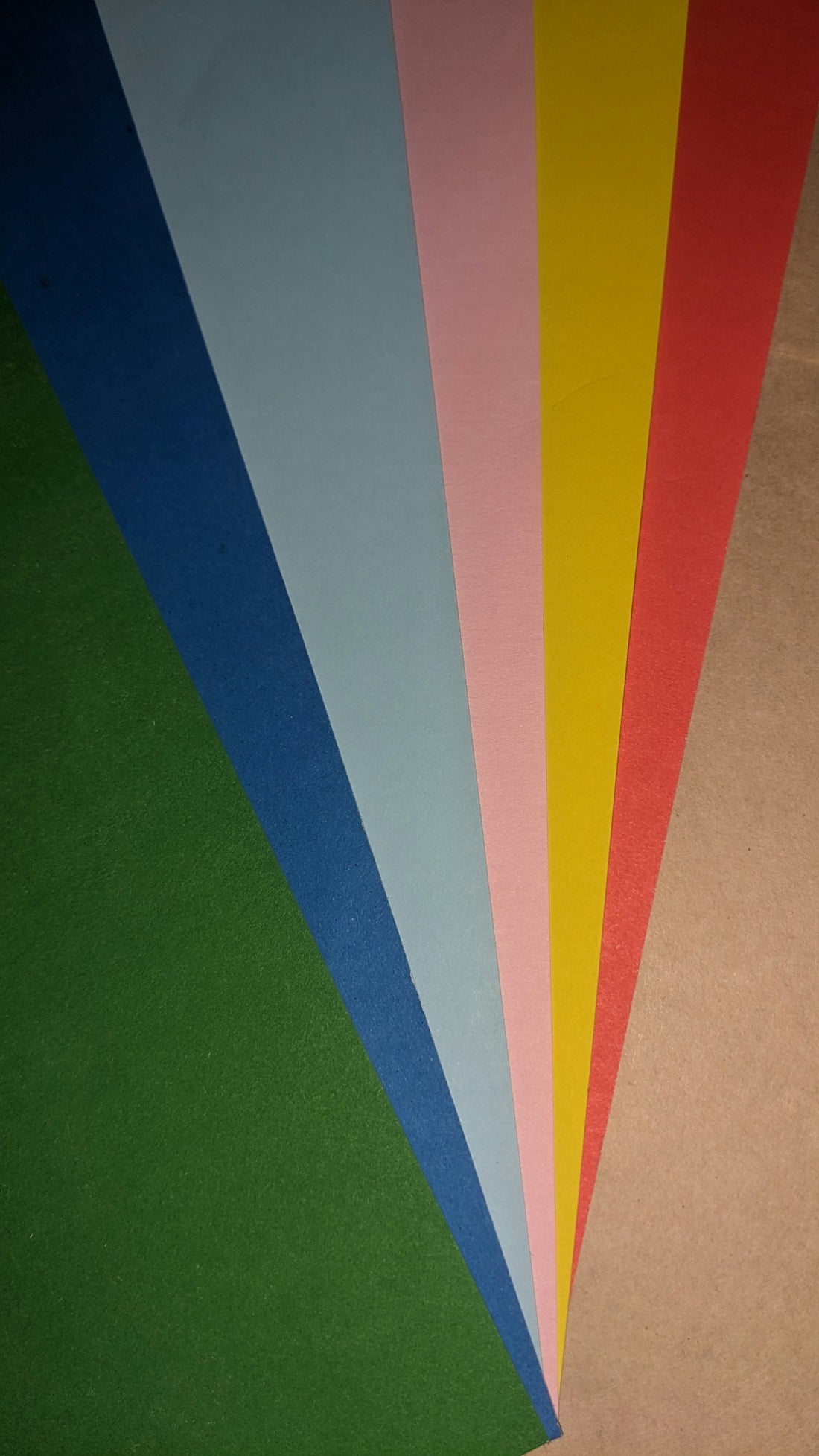 a bunch of different colors of paper on a table