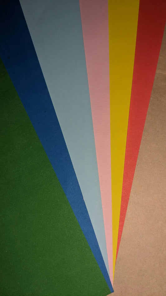 a bunch of different colors of paper on a table
