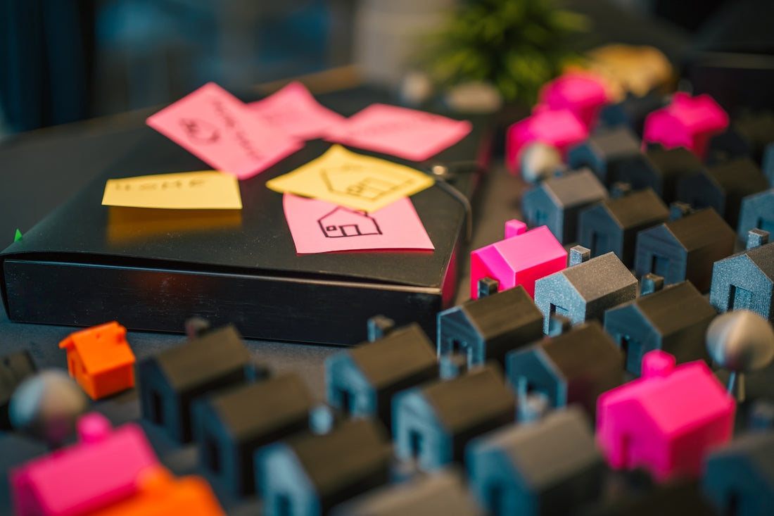 Miniature houses and notes on a dark table.