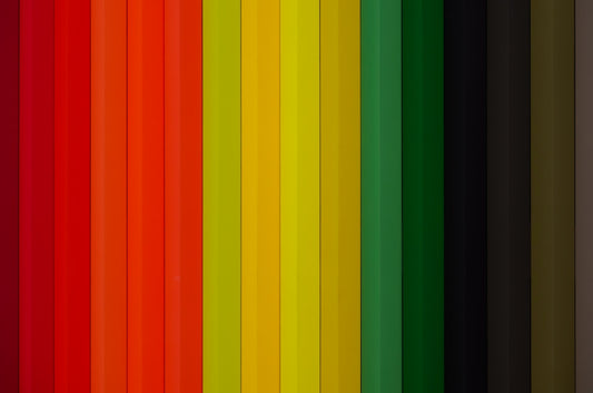 A spectrum of colored pencils arranged vertically.