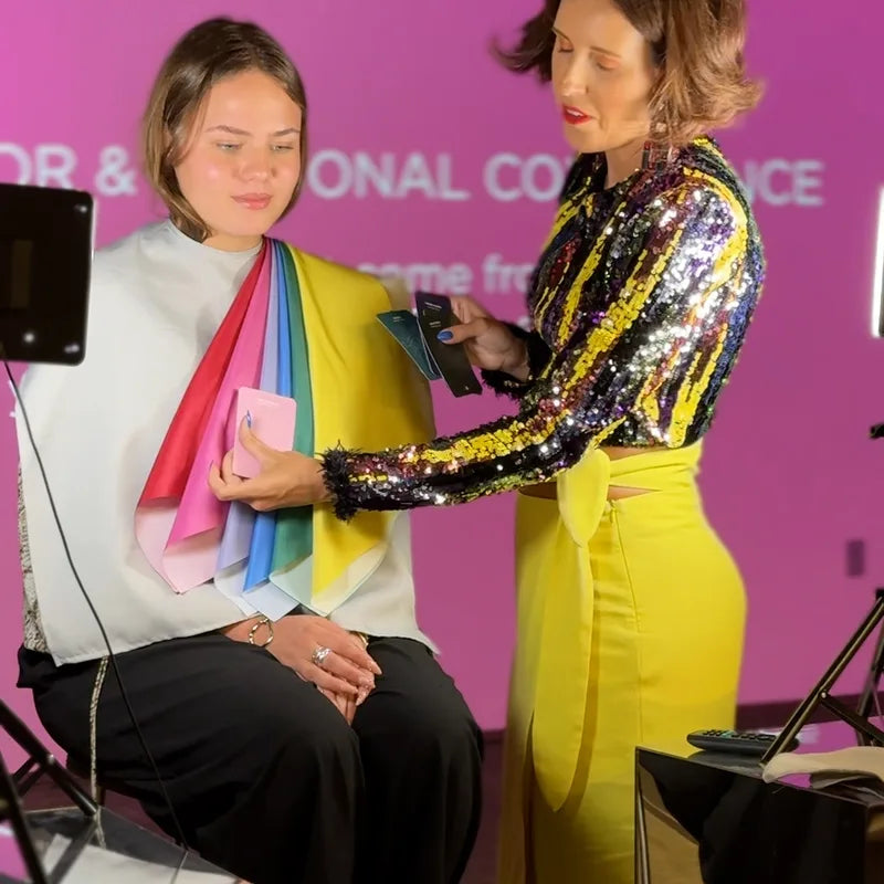 Sissa drapes a client on stage, holding Oracle cards beside the drapes